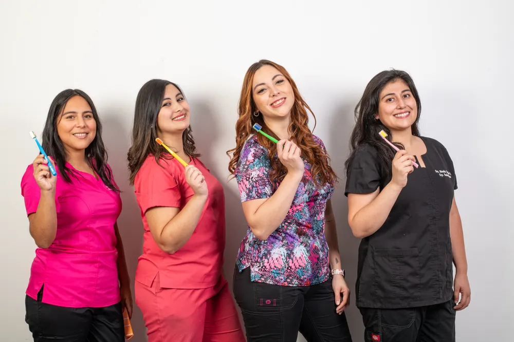 Parte del equipo de Clínica BOK con cepillos de dientes